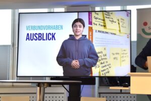 Weiblicher junger Avatar hält eine Präsentation zum Thema 'Assistive Technik'.